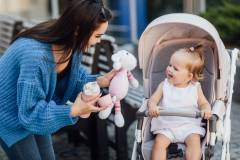 young-sister-walking-with-her-little-cute-sister-outside-give-water-from-her